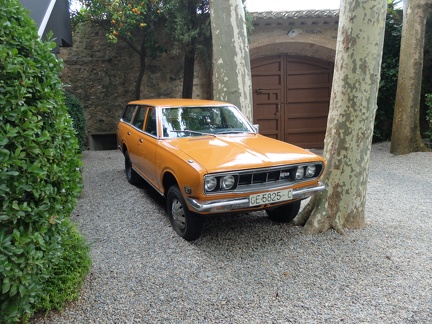 Une Datsun orange garée devant le château de Gala